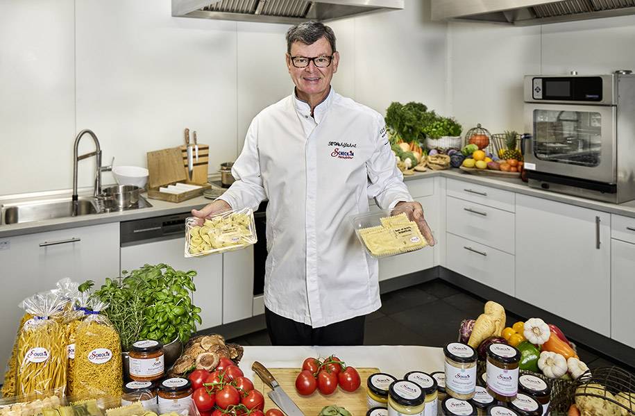 Herr Wohlfahrt hält seine Pasta Gerichte für die Scheck-in Manufaktur in der Hand